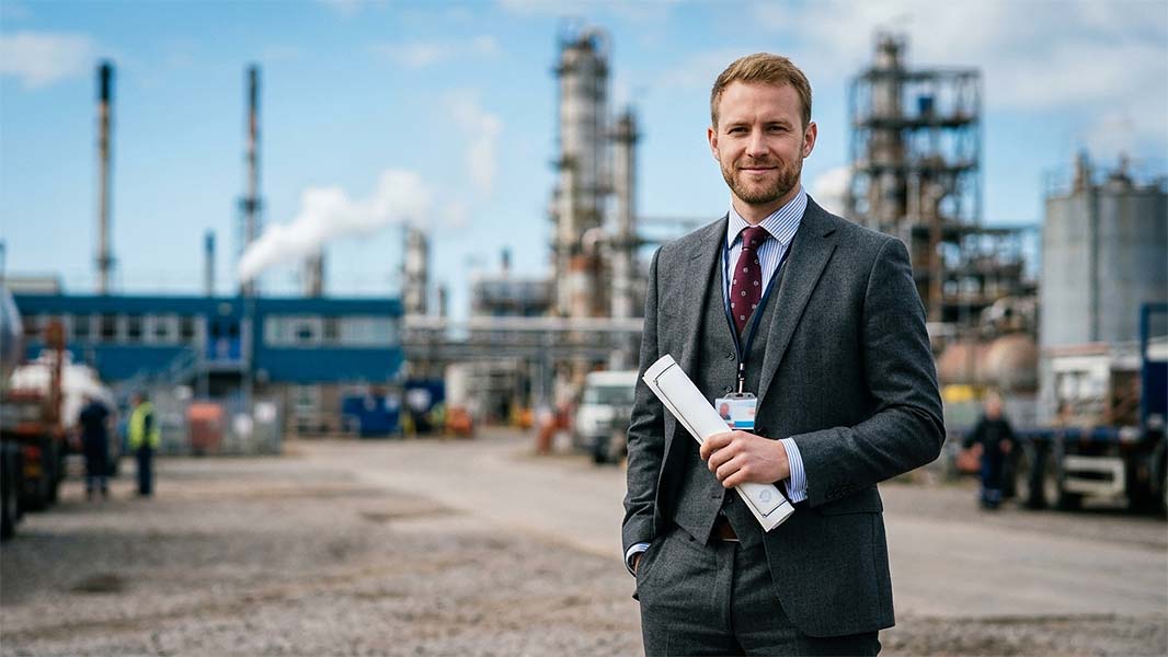 Industrial quality auditor reviewing documents at a refinery site showing benefits of ISO 9001 Lead Auditor Course